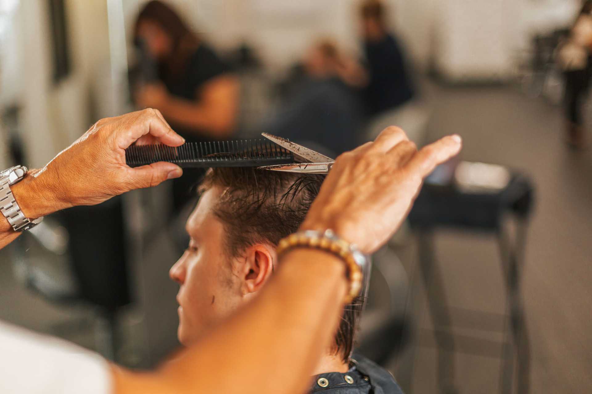 Person getting a haircut in a salon.